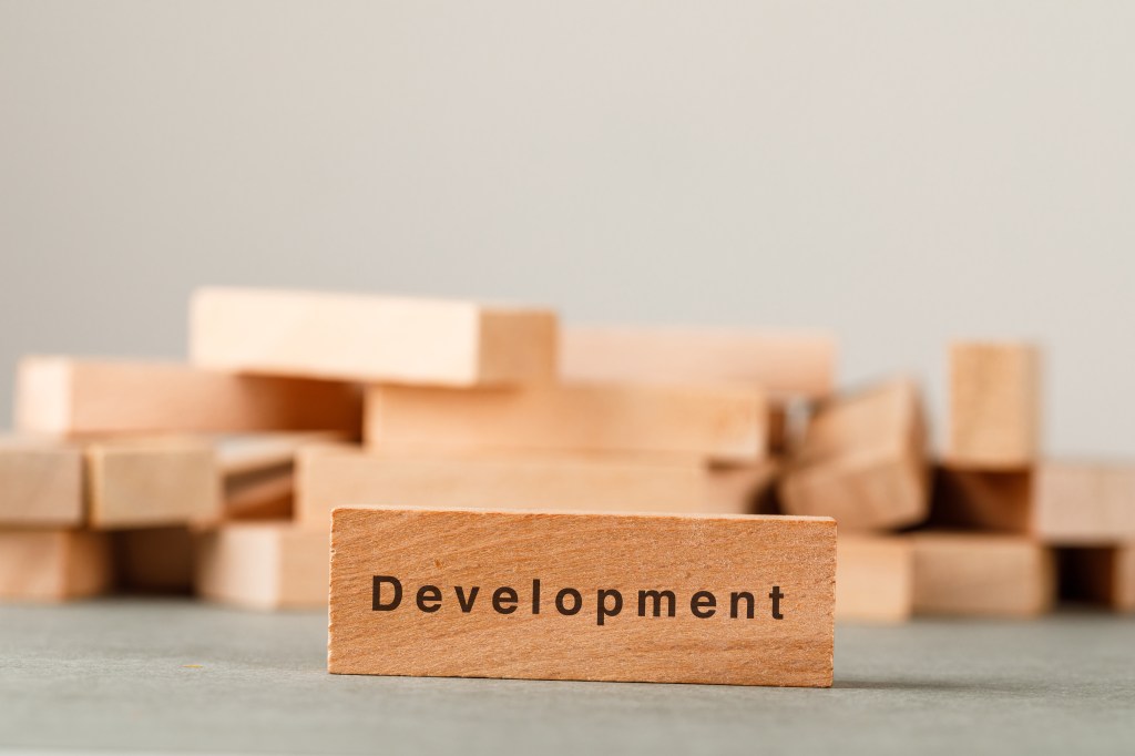 Business strategy and success concept with wooden blocks on grey and white background side view.